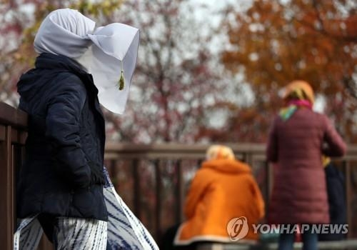 기온이 떨어지고 바람도 불어 쌀쌀한 날씨를 보인 이달 18일 서울 남산에서 기념촬영 중인 한 외국인의 히잡이 바람에 날리고 있다.