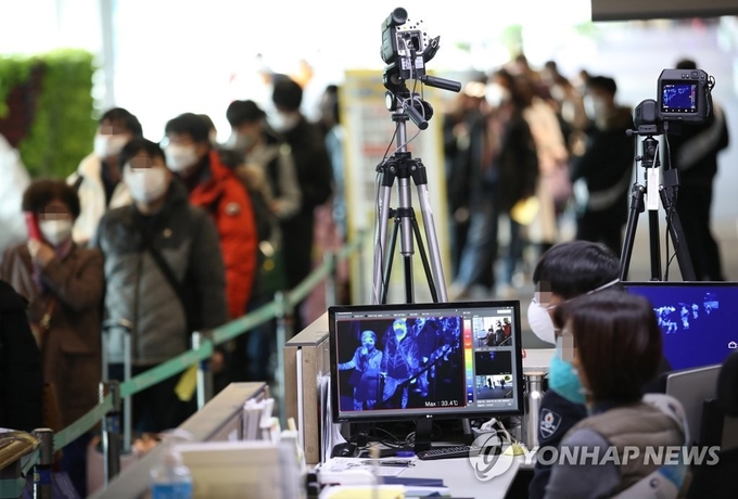 신종 코로나바이러스 감염증인 '우한 폐렴' 공포가 확산하는 가운데 28일 인천국제공항에서 항저우발 항공기 탑승객들이 발열검사를 받기 위해 줄을 서 있다