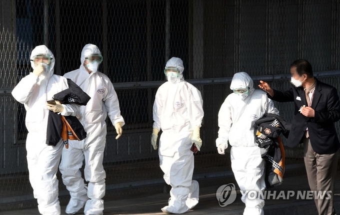 검역 관계자들이 31일 서울 김포국제공항에서 정부 전세기편으로 김포공항에 도착한 우한 교민과 유학생들의 진단을 마친 후 이동하고 있다.