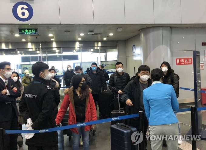 지난 2일 중국 베이징 서우두공항에서 승객들이 신종 코로나바이러스 예방을 위해 마스크를 쓴 채 공항에 들어가려고 기다리고 있다.