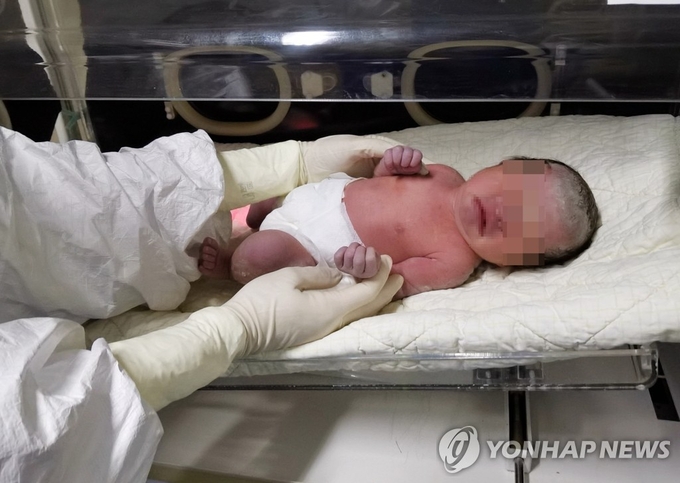 중국 산시성 시안자오퉁대학 제2부속병원에서 10일 간호사가 신종 코로나바이러스에 감염된 산모가 제왕절개 수술을 통해 출산한 여아를 인큐베이터에 넣고 있다. 이 신생아는 바이러스에 감염되지 않은 것으로 밝혀졌다.