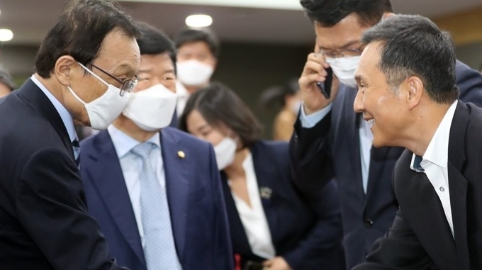 더불어민주당 이해찬 대표와 김연명 청와대 사회수석이 13일 오후 서울 여의도 국회 의원회관에서 열린 제21대 국회의원 당선인 혁신포럼 '포스트코로나 전망과 문재인정부 과제'에서 악수하고 있다.
