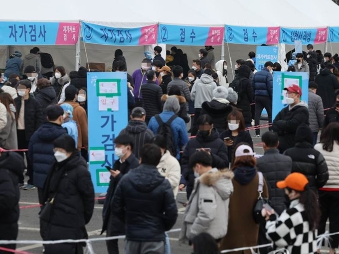 13일 오후 송파구 잠실종합운동장 제2주차장 선별진료소에서 시민들이 검사를 받기 위해 줄을 서있다. 중앙방역대책본부는 이날 0시 기준으로 코로나19 확진자가 5만4천941명 늘어 누적 129만4천205명이라고 밝혔다.