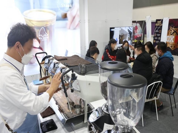 5일 오전 서울 강남구 코엑스에서 열린 '제68회 프랜차이즈 창업박람회 2023'에서 한 카페 부스 관계자가 커피를 준비하고 있다